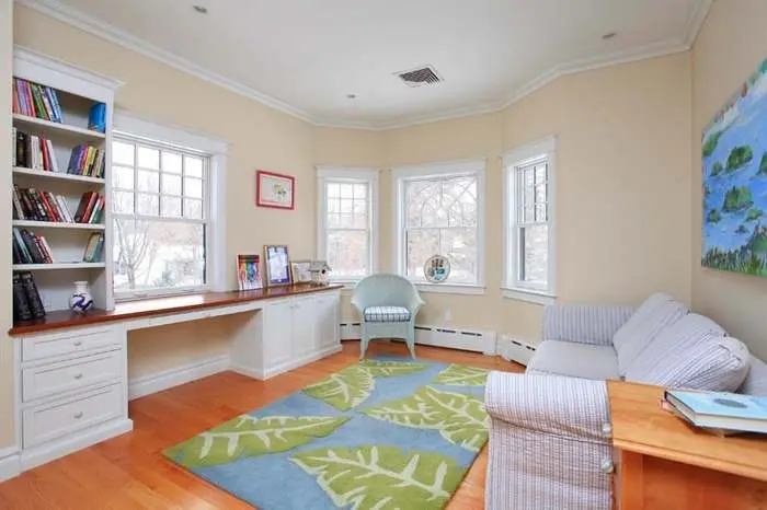 Sitting area with a writing desk and broad windows overlooking the water