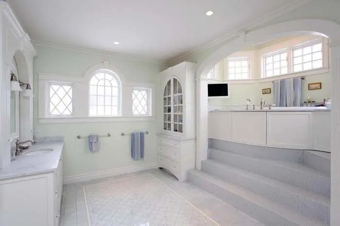 Bright bathroom with a long fitted vanity and tiled shower