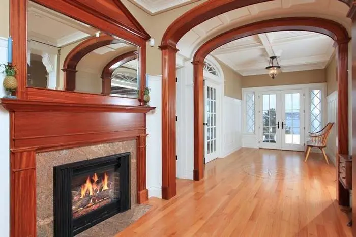 Formal entry and sitting room with arched millwork around the fireplace